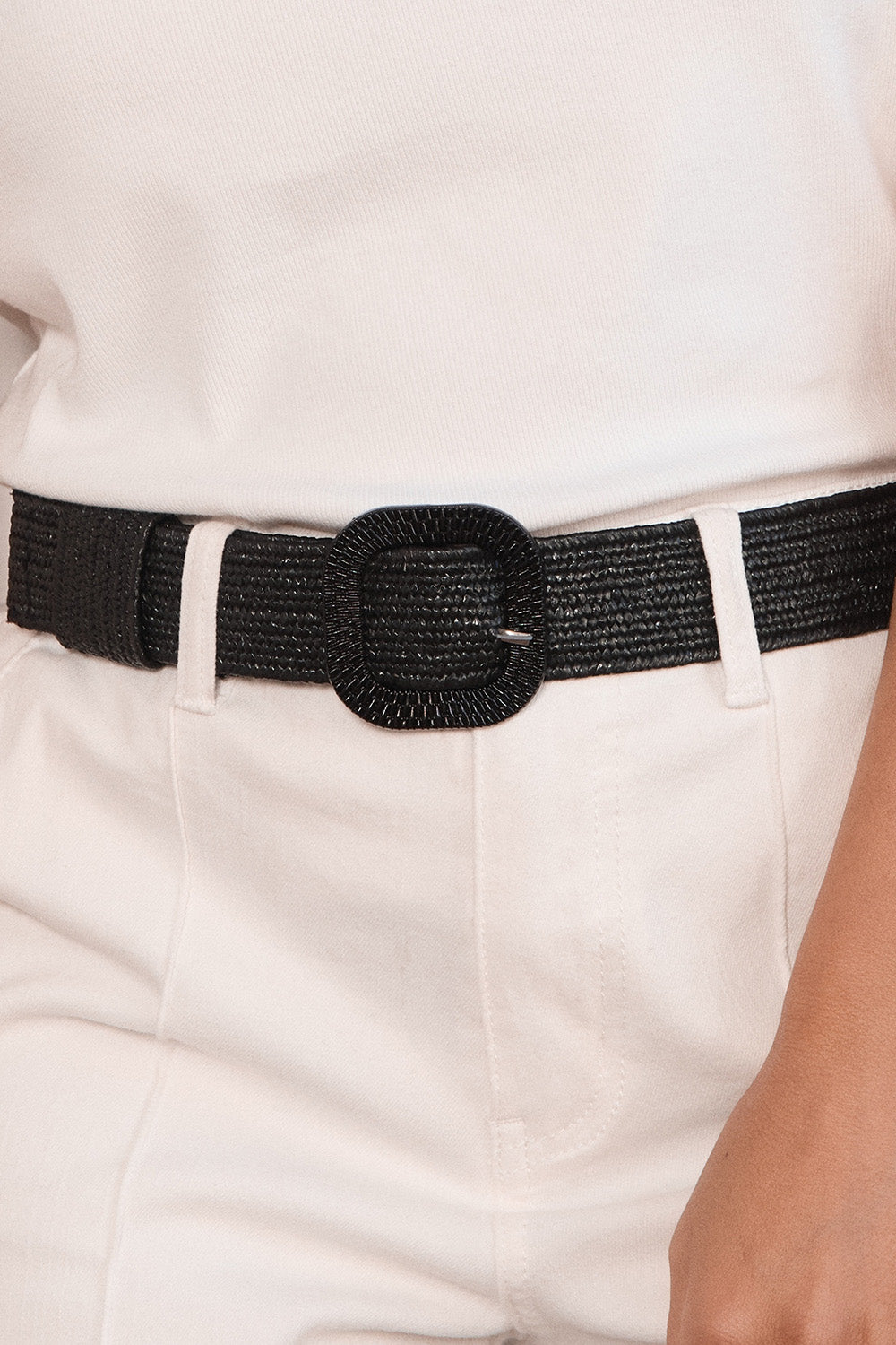 Black belt with a large buckle worn on white pants