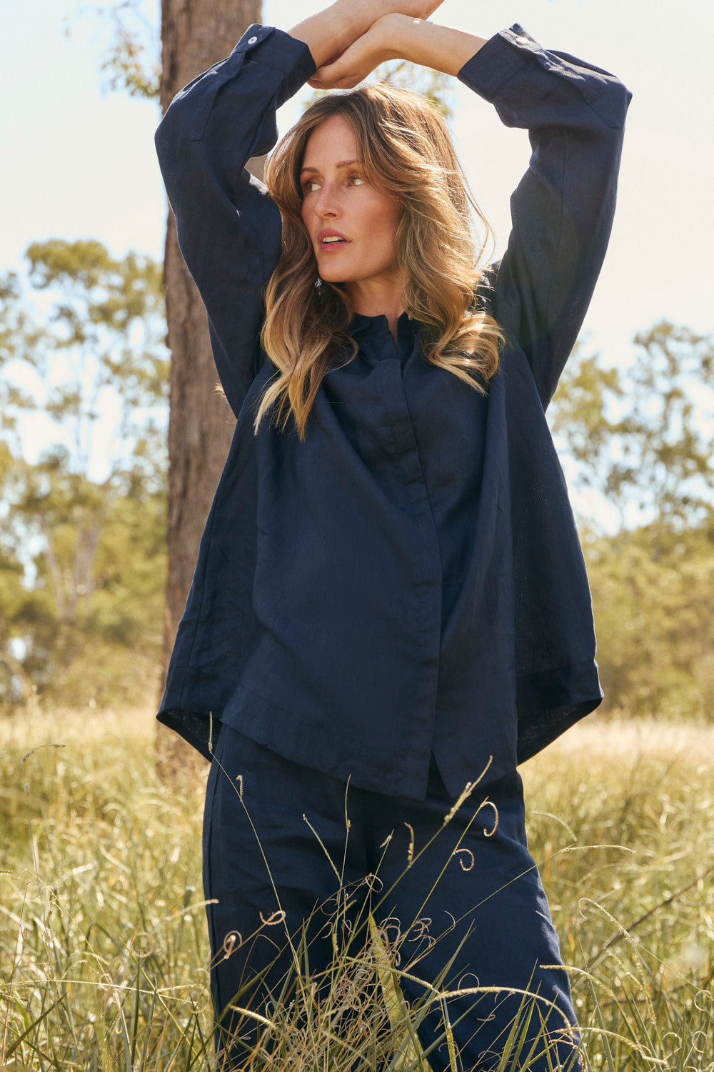 Model wearing the Oversized Linen Boyfriend Shirt in Navy with curved high-low hemline, Adrift Clothing
