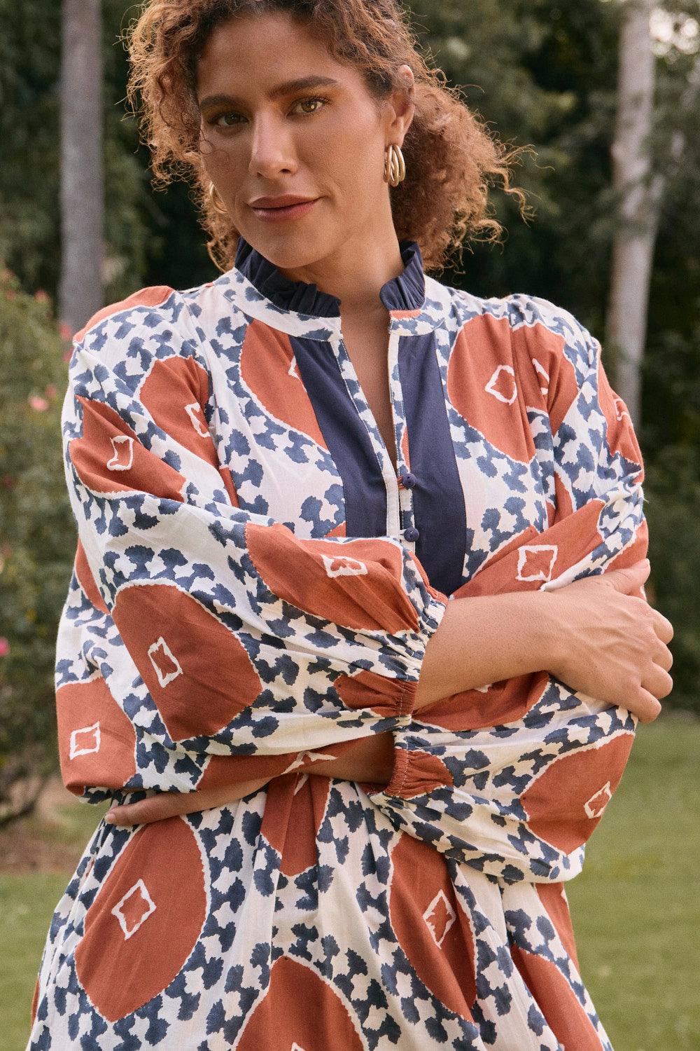 Woman wearing a patterned dress with a blurred natural background