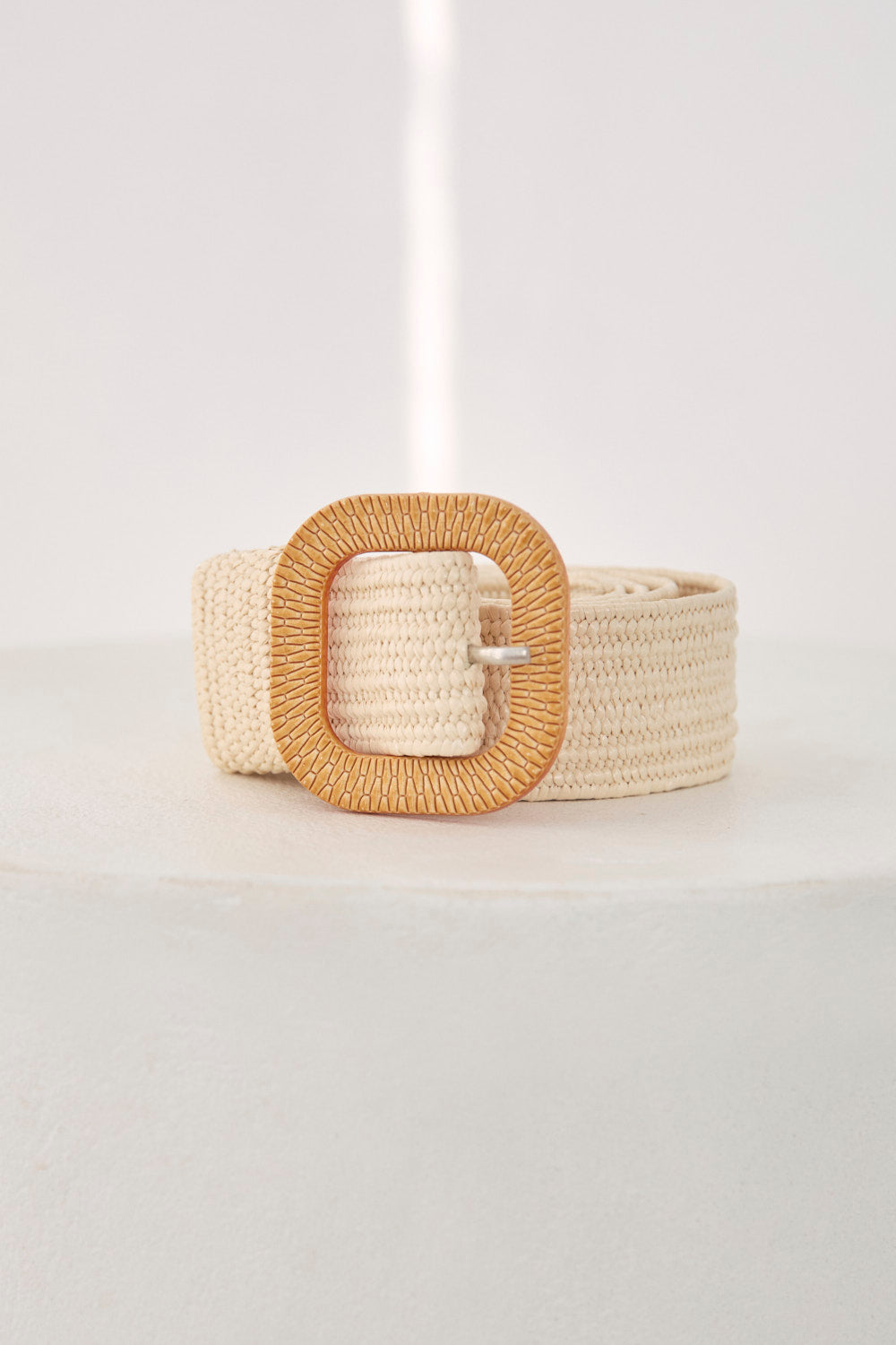 Beige woven belt with a gold buckle on a light gray background