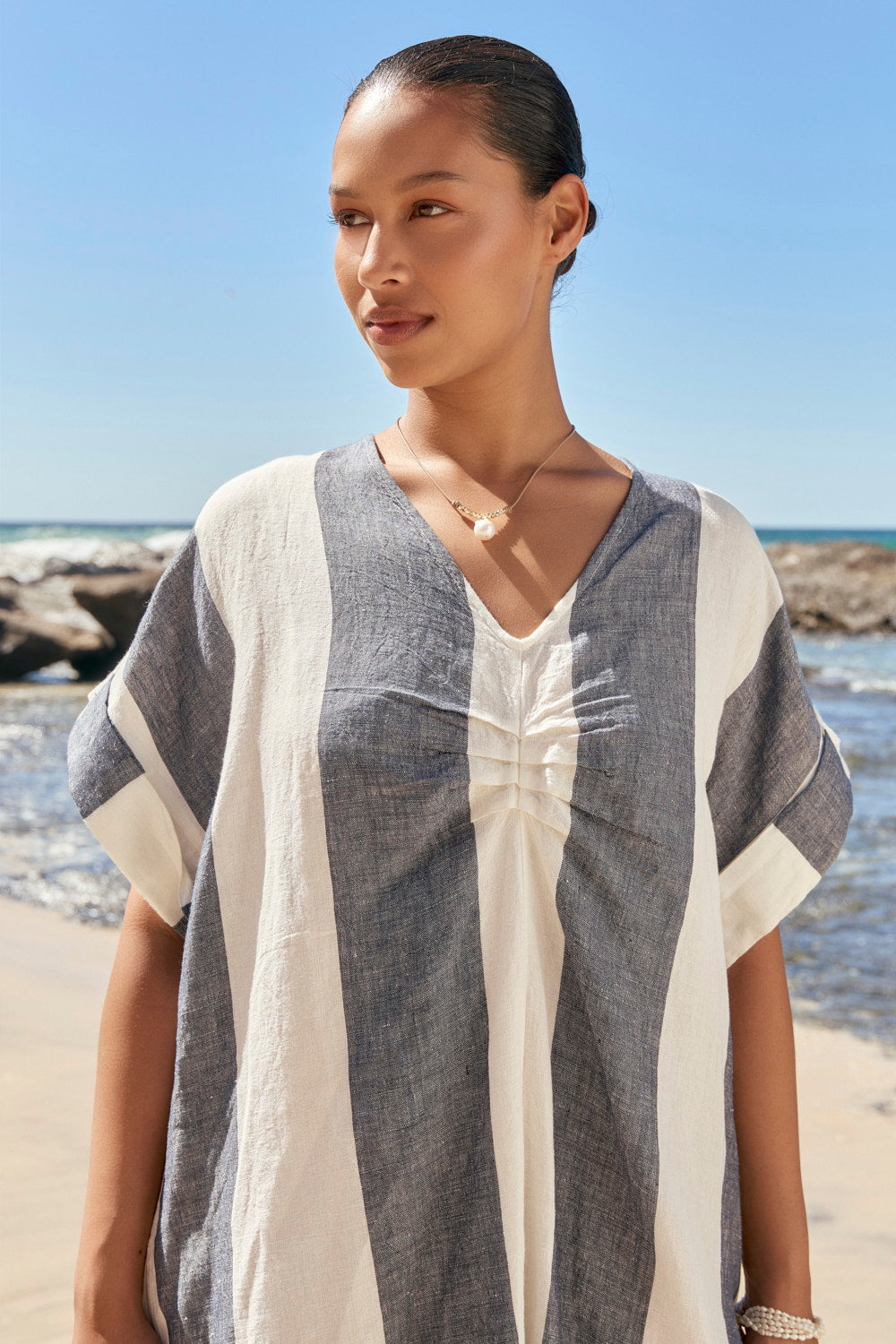Woman wearing a gray and white cover-up on a beach